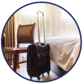 a chair and rolling suitcase in a hotel room